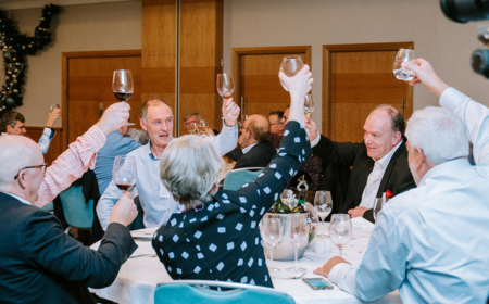 A groups of UCD alumni at a reunion, raising their glasses.